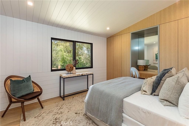 bedroom with wooden walls, wood ceiling, vaulted ceiling, and light wood-type flooring