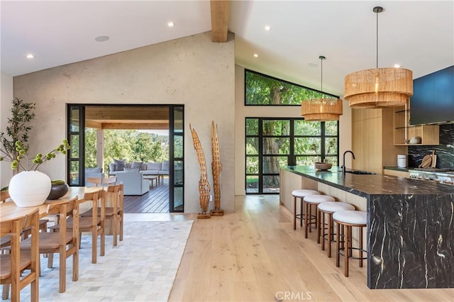 kitchen with pendant lighting, a kitchen breakfast bar, a healthy amount of sunlight, and light wood-type flooring