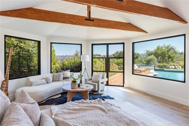 sunroom with lofted ceiling with beams and plenty of natural light