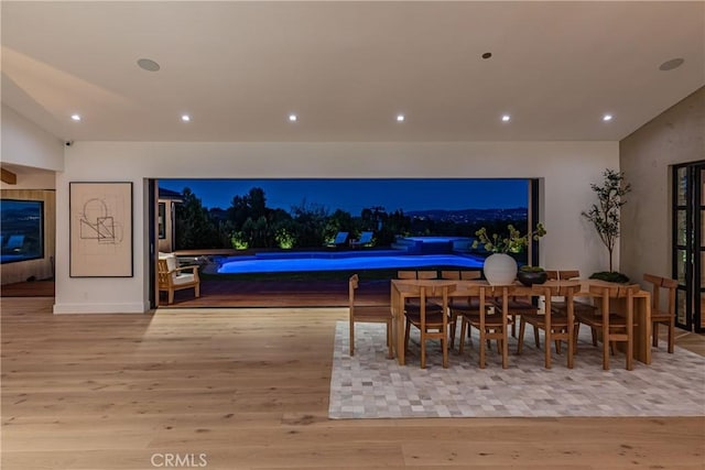 dining room featuring light hardwood / wood-style floors and vaulted ceiling