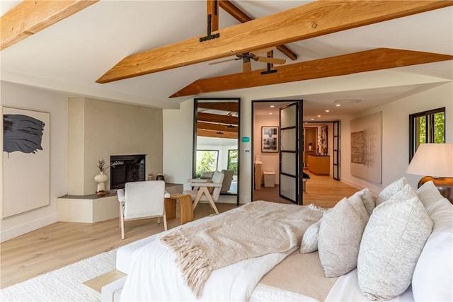 bedroom featuring vaulted ceiling with beams and light hardwood / wood-style flooring