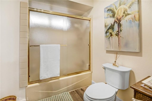 bathroom featuring shower / bath combination with glass door, wood-type flooring, and toilet