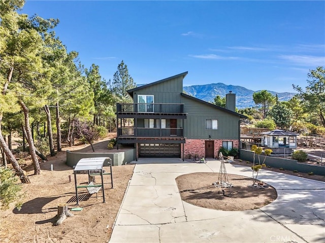 view of front of property featuring a mountain view, a balcony, and a garage