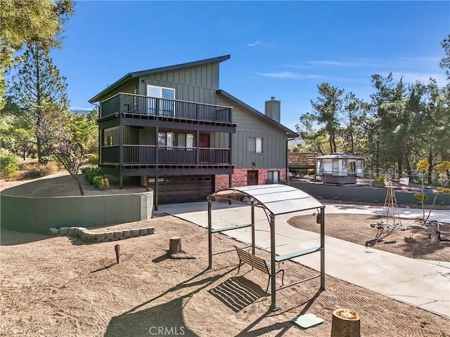 rear view of house with a balcony and a garage