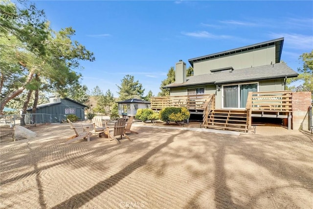 rear view of property with a deck and an outdoor fire pit