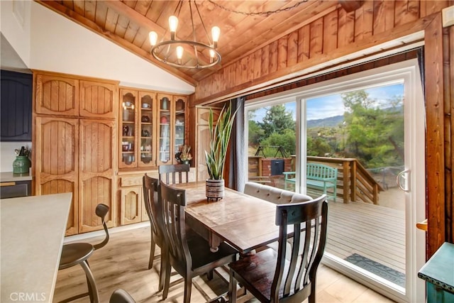 dining space featuring a notable chandelier, lofted ceiling, light wood-type flooring, and wood ceiling