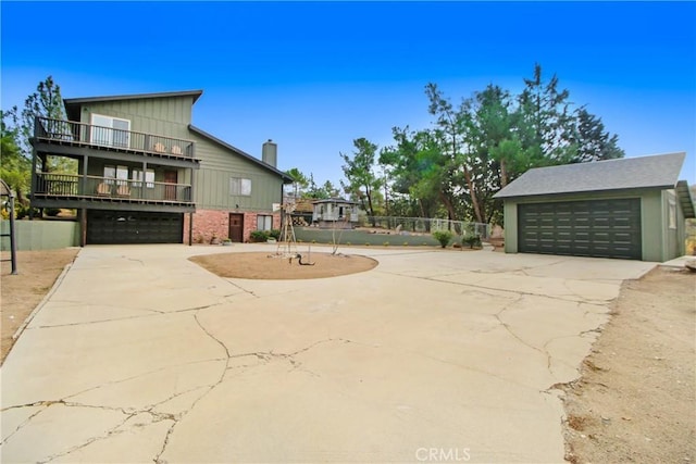 view of property exterior with an outbuilding, a balcony, and a garage