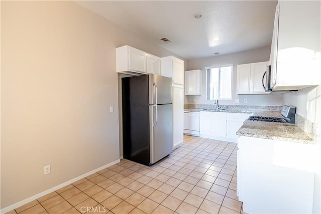 kitchen featuring sink, light tile patterned floors, light stone counters, white cabinetry, and stainless steel appliances