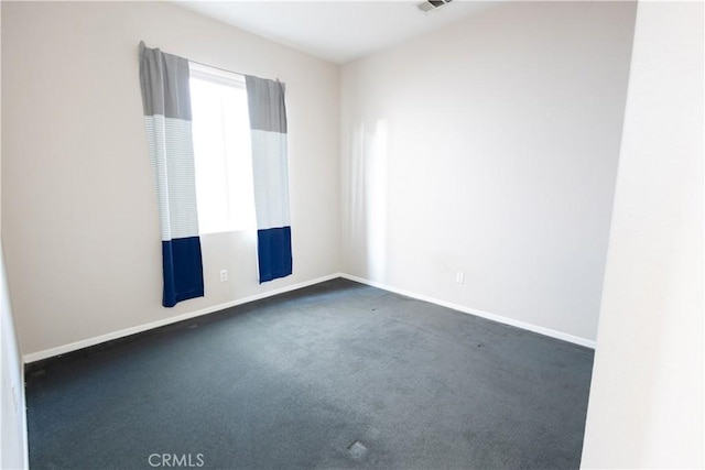 unfurnished room featuring dark carpet