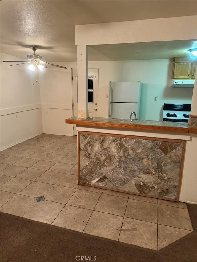24144 Joshua Ave, Boron, CA 93516 - kitchen with light tile patterned floors, ceiling fan, white appliances, and under cabinet range hood