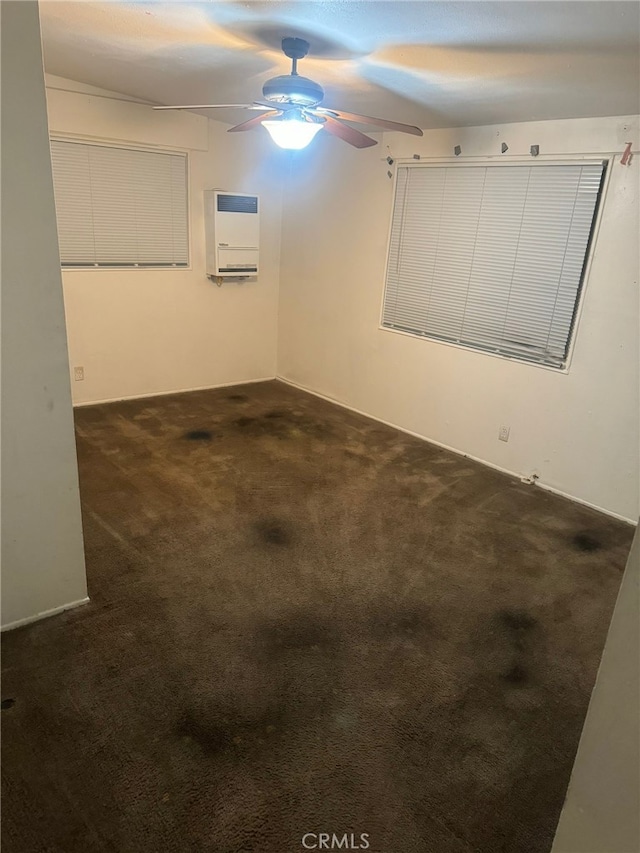 spare room featuring ceiling fan and dark colored carpet