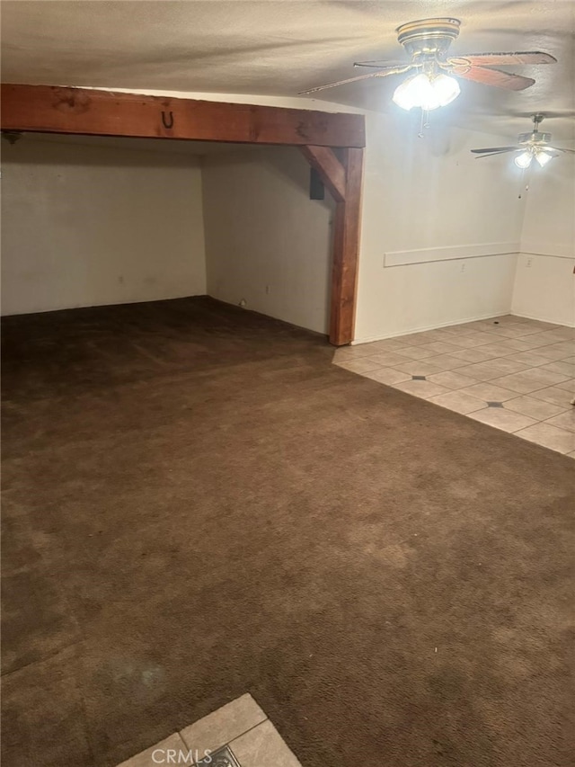 basement featuring carpet floors, a ceiling fan, and tile patterned floors