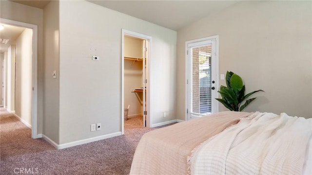 bedroom featuring light carpet, a closet, a walk in closet, and lofted ceiling