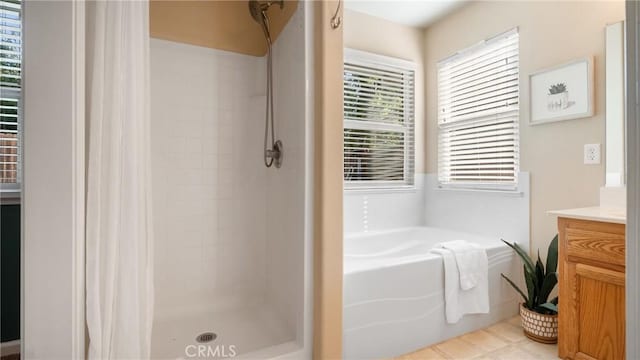 bathroom with tile patterned flooring, separate shower and tub, and vanity