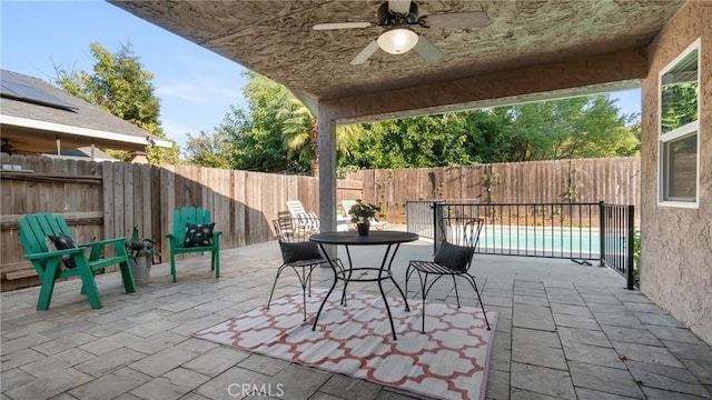 view of patio / terrace with ceiling fan and a fenced in pool