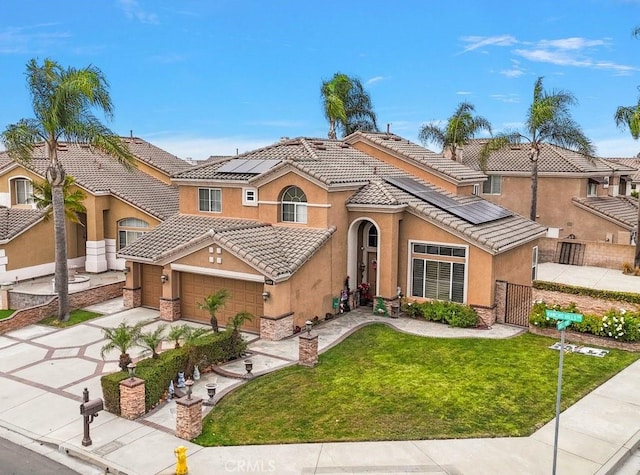 mediterranean / spanish home with a garage, a front lawn, and solar panels