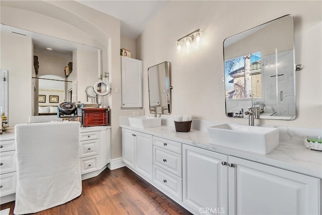 bathroom with hardwood / wood-style flooring, vanity, and a shower