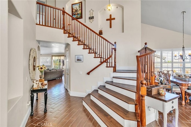 stairs with a chandelier and a high ceiling