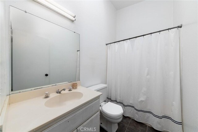 bathroom featuring toilet, vanity, and tile patterned floors