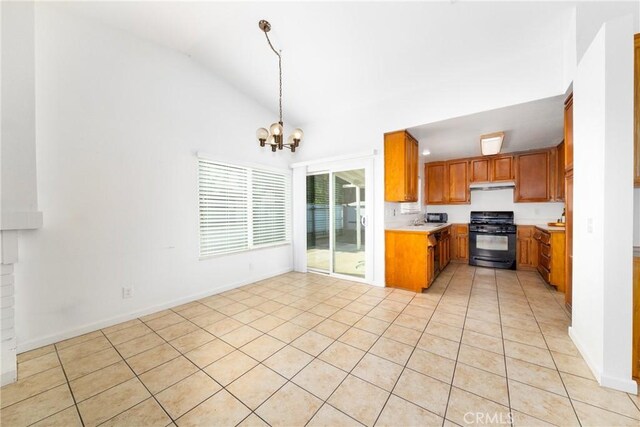 kitchen with gas stove, hanging light fixtures, high vaulted ceiling, a chandelier, and light tile patterned floors