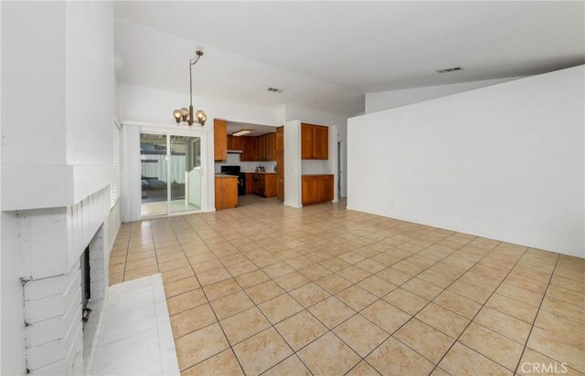 unfurnished living room featuring a chandelier, light tile patterned floors, and lofted ceiling