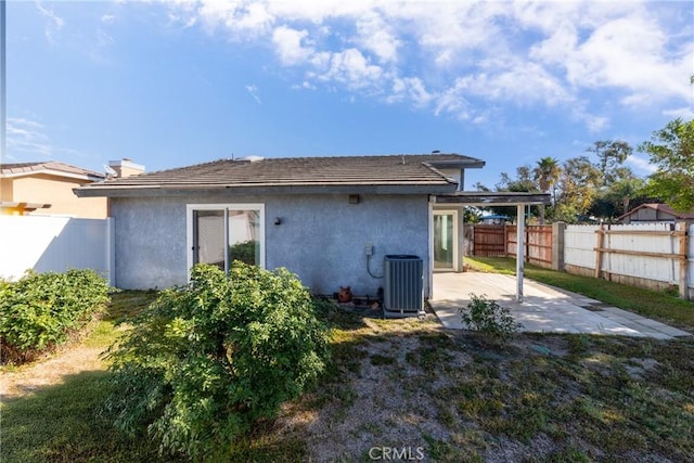 rear view of property with central AC unit and a patio area