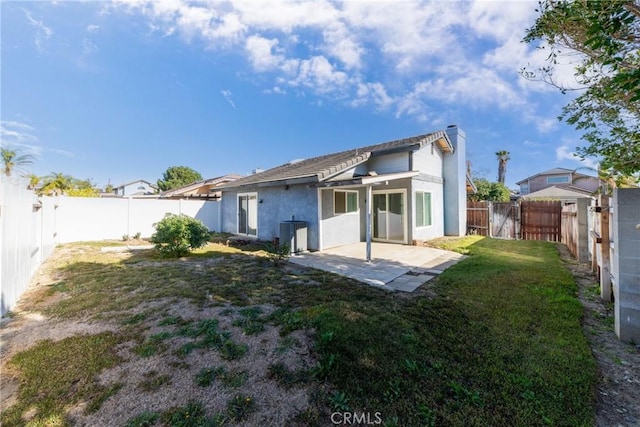 rear view of house featuring a patio area, a yard, and central AC