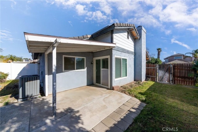 rear view of house featuring a yard, a patio, and central AC unit