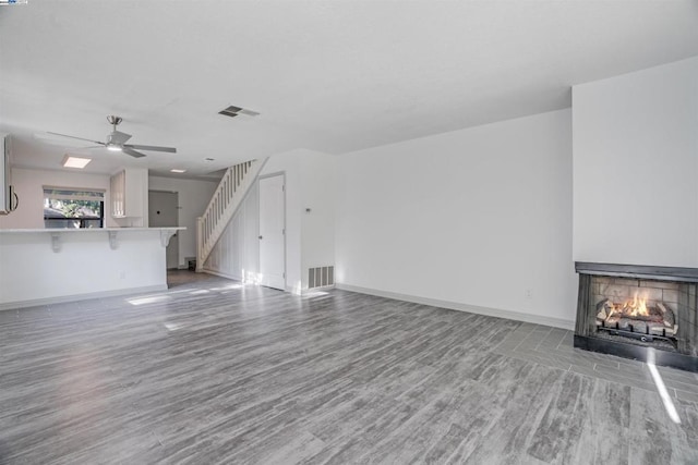 unfurnished living room featuring light wood-type flooring and ceiling fan