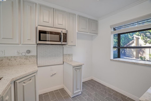 kitchen featuring light stone counters and ornamental molding