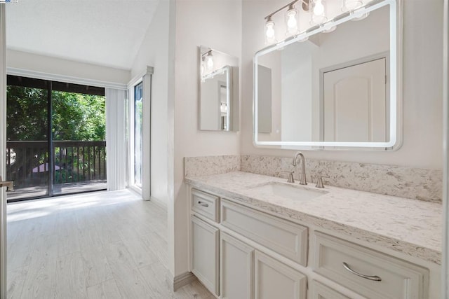 bathroom featuring vanity, lofted ceiling, and hardwood / wood-style flooring