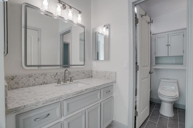 bathroom featuring tile patterned floors, vanity, and toilet