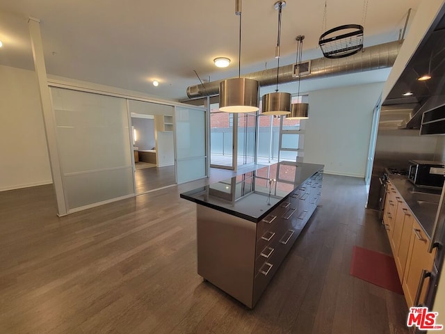 kitchen featuring dark wood-type flooring, a kitchen island, and pendant lighting