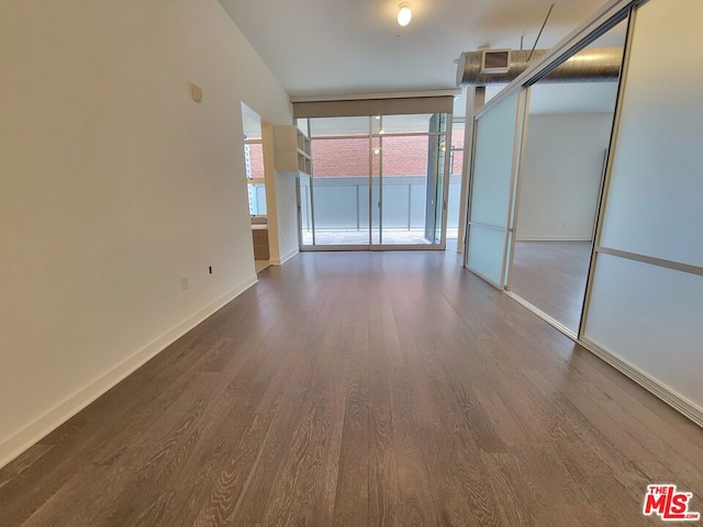 empty room featuring dark wood-type flooring and floor to ceiling windows