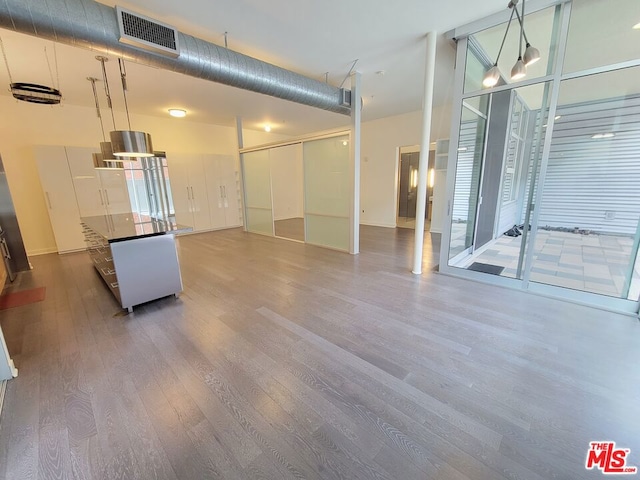 interior space featuring a towering ceiling and hardwood / wood-style floors