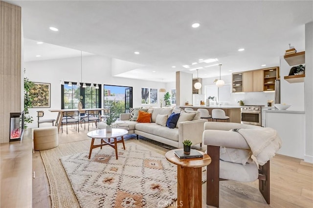 living room with light wood-type flooring and lofted ceiling