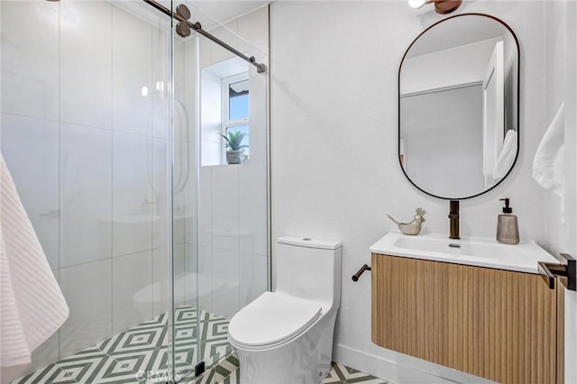 bathroom featuring vanity, toilet, and a shower with shower door