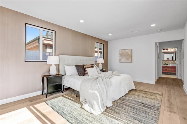 bedroom with light wood-type flooring and ensuite bathroom