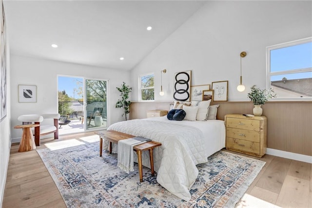 bedroom featuring access to outside, high vaulted ceiling, and light hardwood / wood-style floors