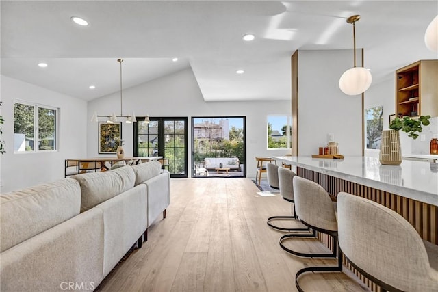 living room featuring light hardwood / wood-style floors and vaulted ceiling