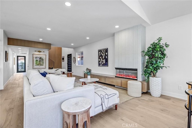 living room with a fireplace and light wood-type flooring