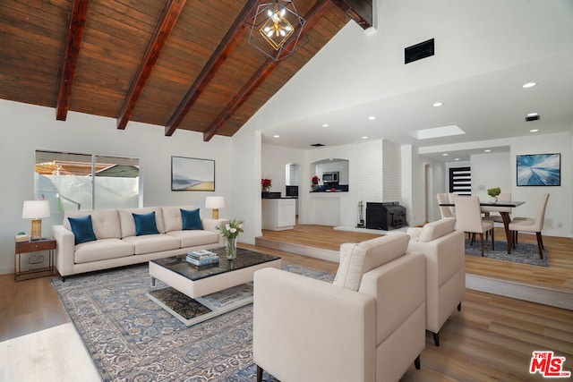 living room featuring beam ceiling, high vaulted ceiling, wooden ceiling, a chandelier, and hardwood / wood-style floors