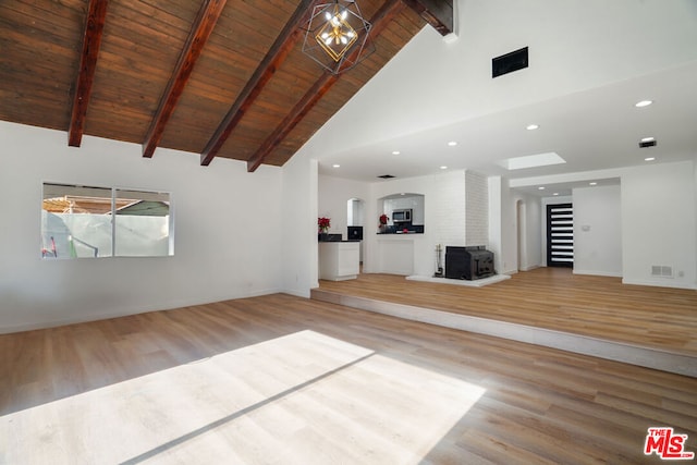 unfurnished living room with a wood stove, beamed ceiling, high vaulted ceiling, wood ceiling, and hardwood / wood-style flooring