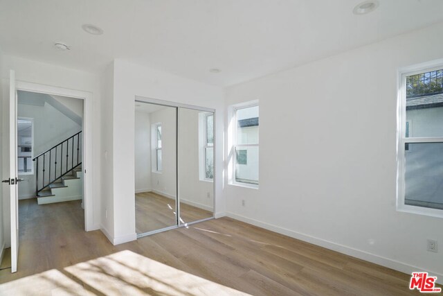 unfurnished bedroom featuring light hardwood / wood-style flooring and a closet