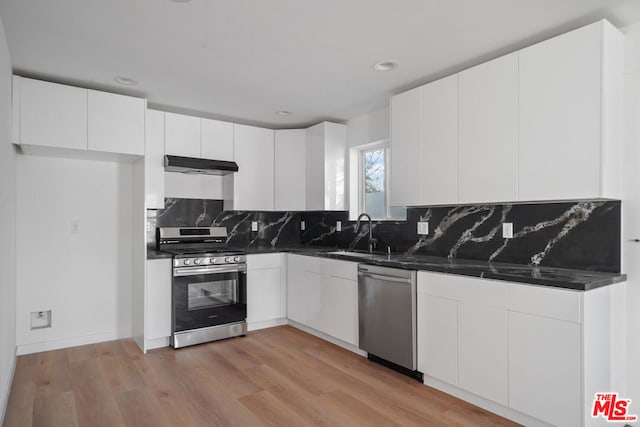 kitchen featuring white cabinets, appliances with stainless steel finishes, light hardwood / wood-style floors, and sink