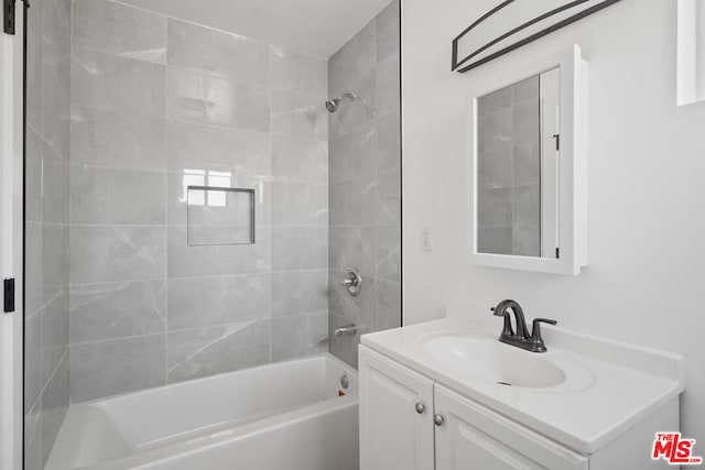 bathroom featuring vanity and tiled shower / bath