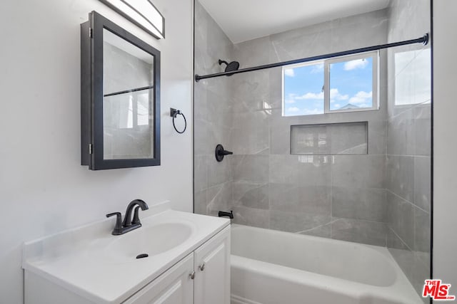 bathroom with vanity and tiled shower / bath combo