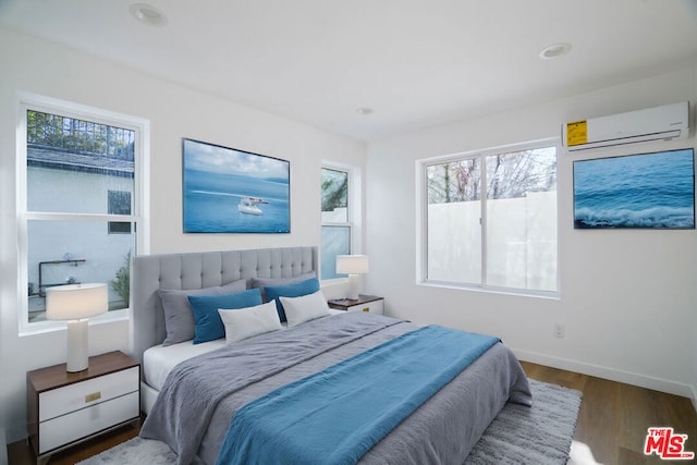 bedroom featuring dark hardwood / wood-style floors and an AC wall unit