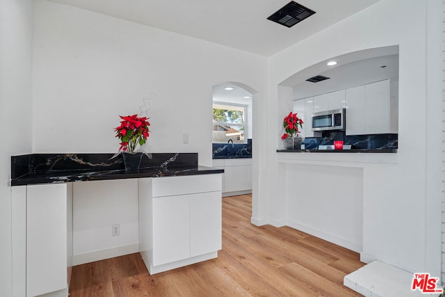 kitchen with light hardwood / wood-style floors and white cabinetry