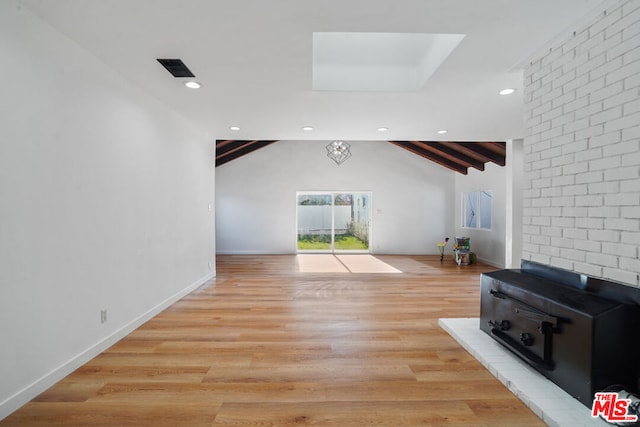 unfurnished living room with vaulted ceiling with beams and light hardwood / wood-style floors